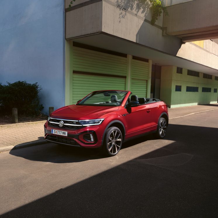 Ein rotes VW T-Roc Cabrio mit geöffnetem Dach von vorne.