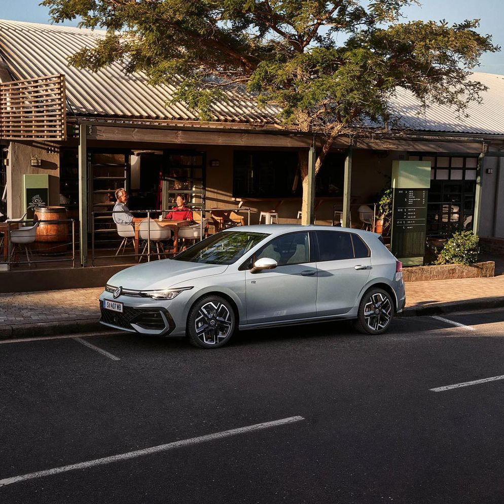 Der neue Golf GTE parkt an einem Straßenrand neben einem Café.