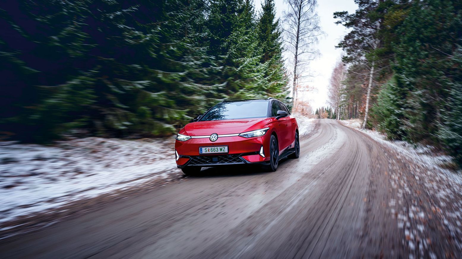 Ein roter VW ID.7 GTX fährt in Waldstraße im Winter