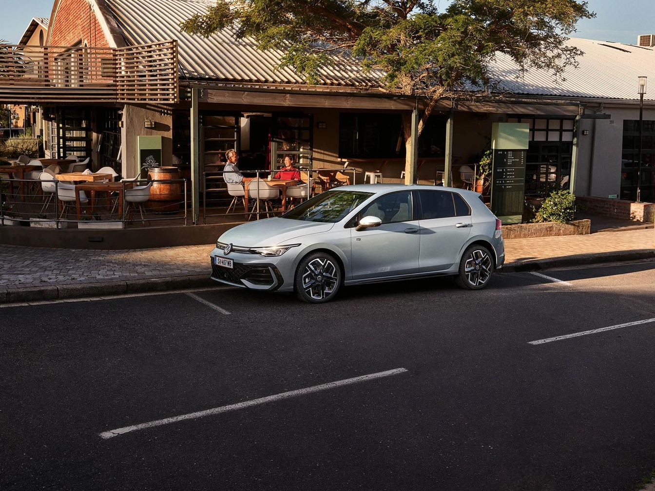 Der neue Golf GTE parkt an einem Straßenrand neben einem Café.