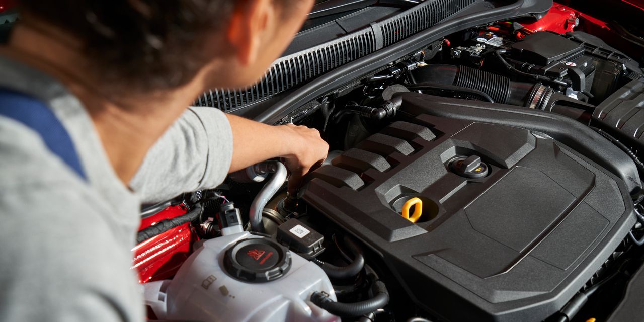 Ein VW Service Techniker wechselt die Glühkerzen bei einem Volkswagen