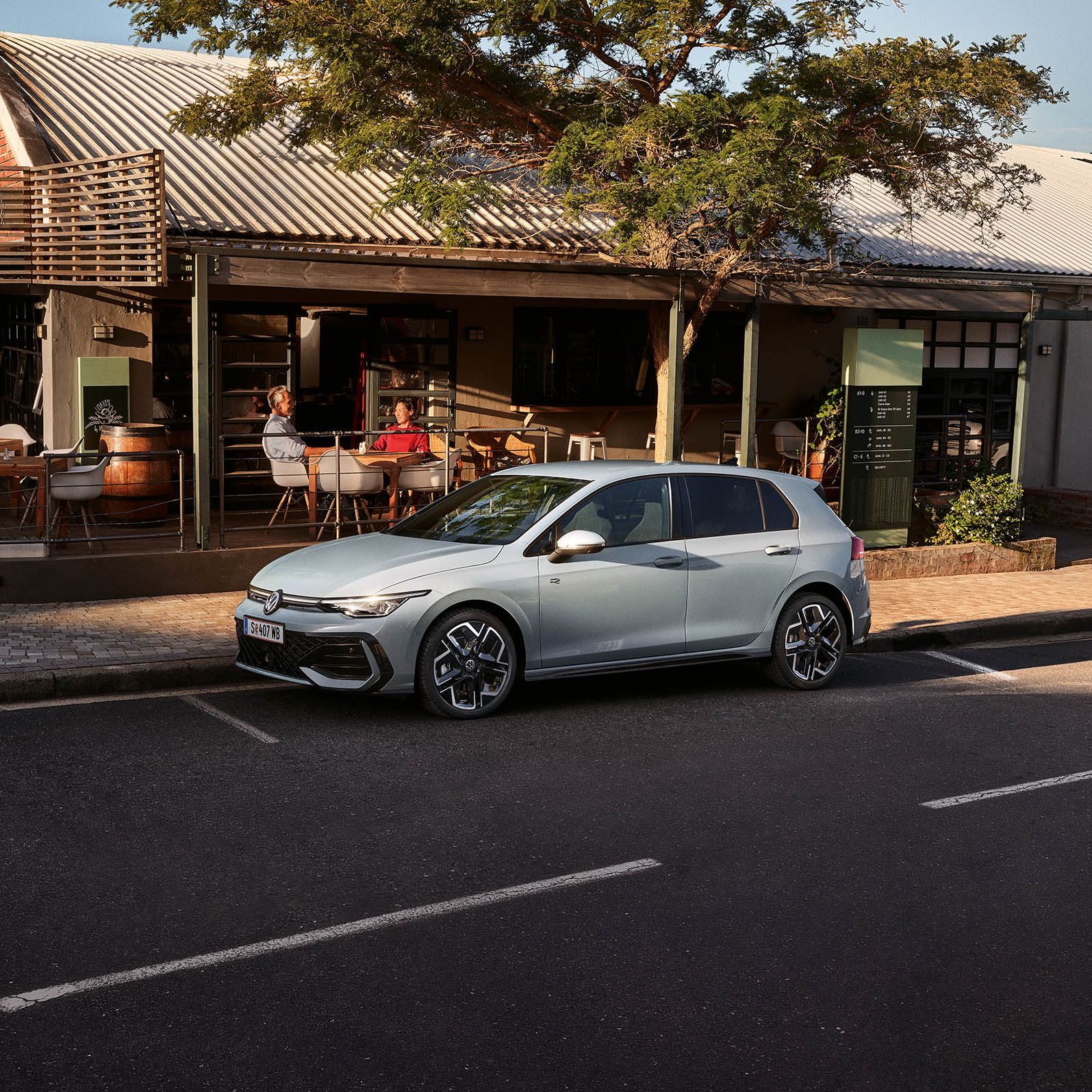 Der neue Golf GTE parkt an einem Straßenrand neben einem Café.