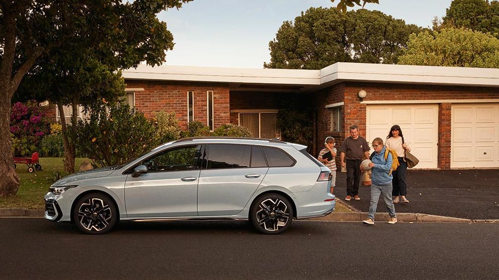 Seitenansicht eines VW Golf Variant in der Farbe Ice Blue Metallic geparkt vor Einfamilienhaus