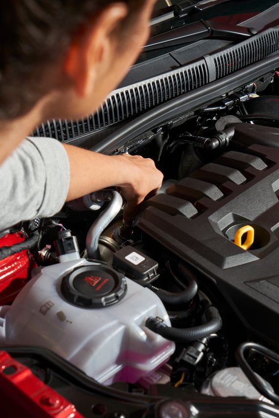 Ein VW Service Techniker wechselt die Glühkerzen bei einem Volkswagen