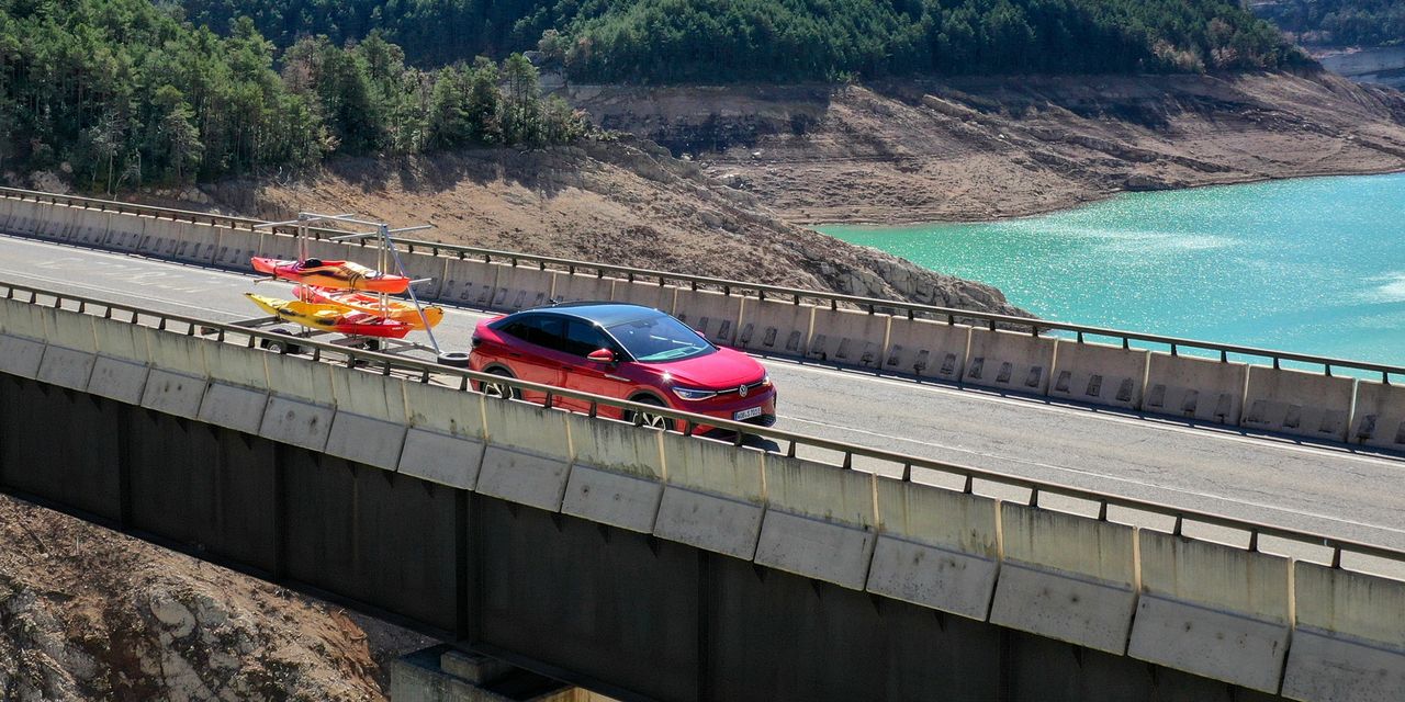 Ein roter ID.5 GTX fährt mit einem Anhänger über eine Brücke