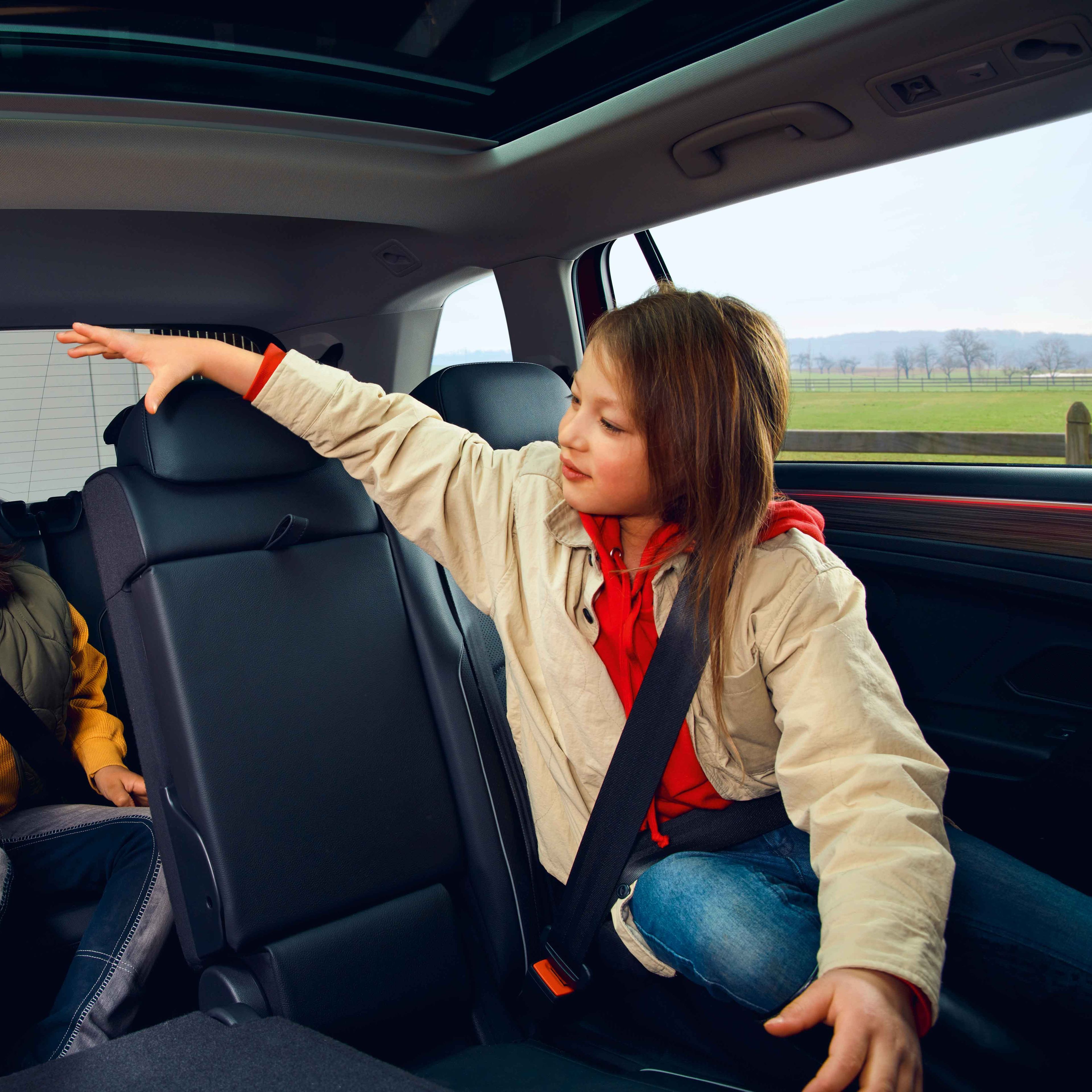 Zwei Kinder spielen auf der Rücksitzbank des VW Tiguan Allspace