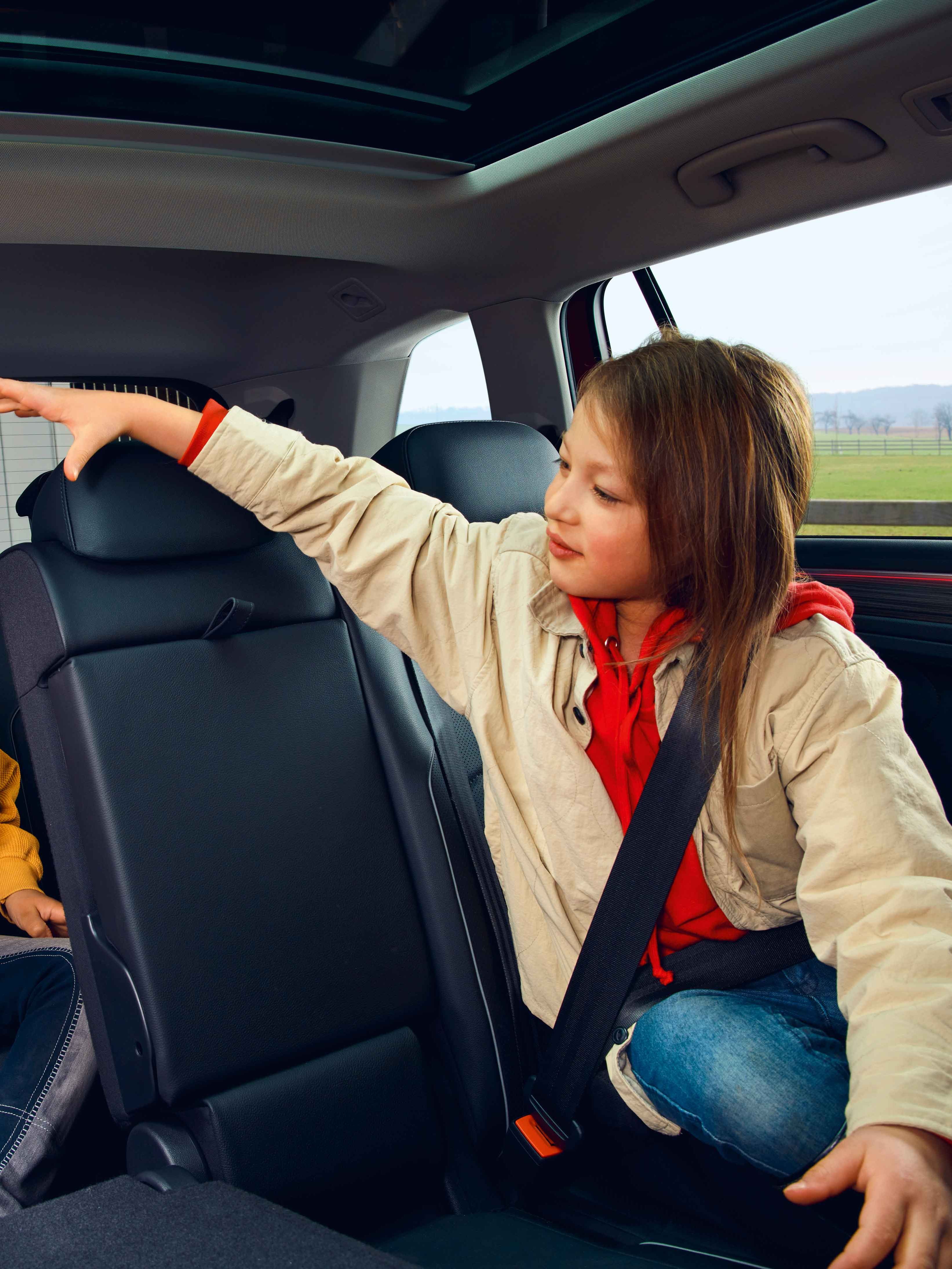 Zwei Kinder spielen auf der Rücksitzbank des VW Tiguan Allspace