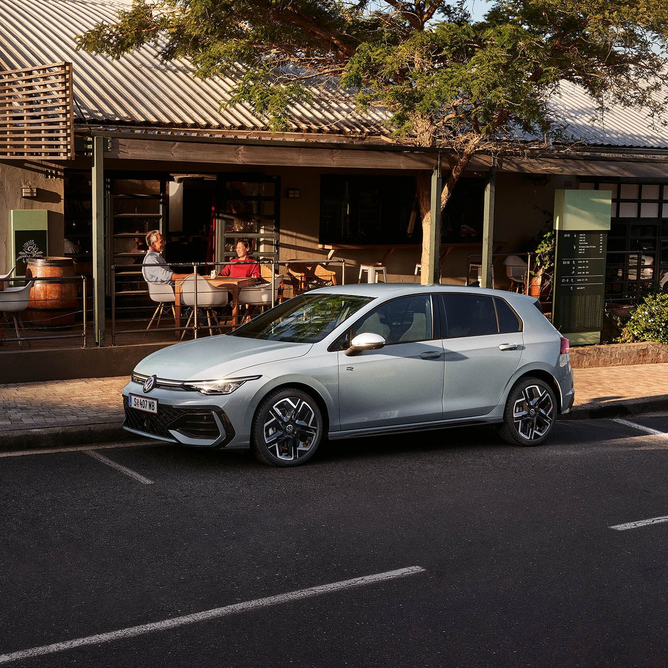 Der neue Golf GTE parkt an einem Straßenrand neben einem Café.