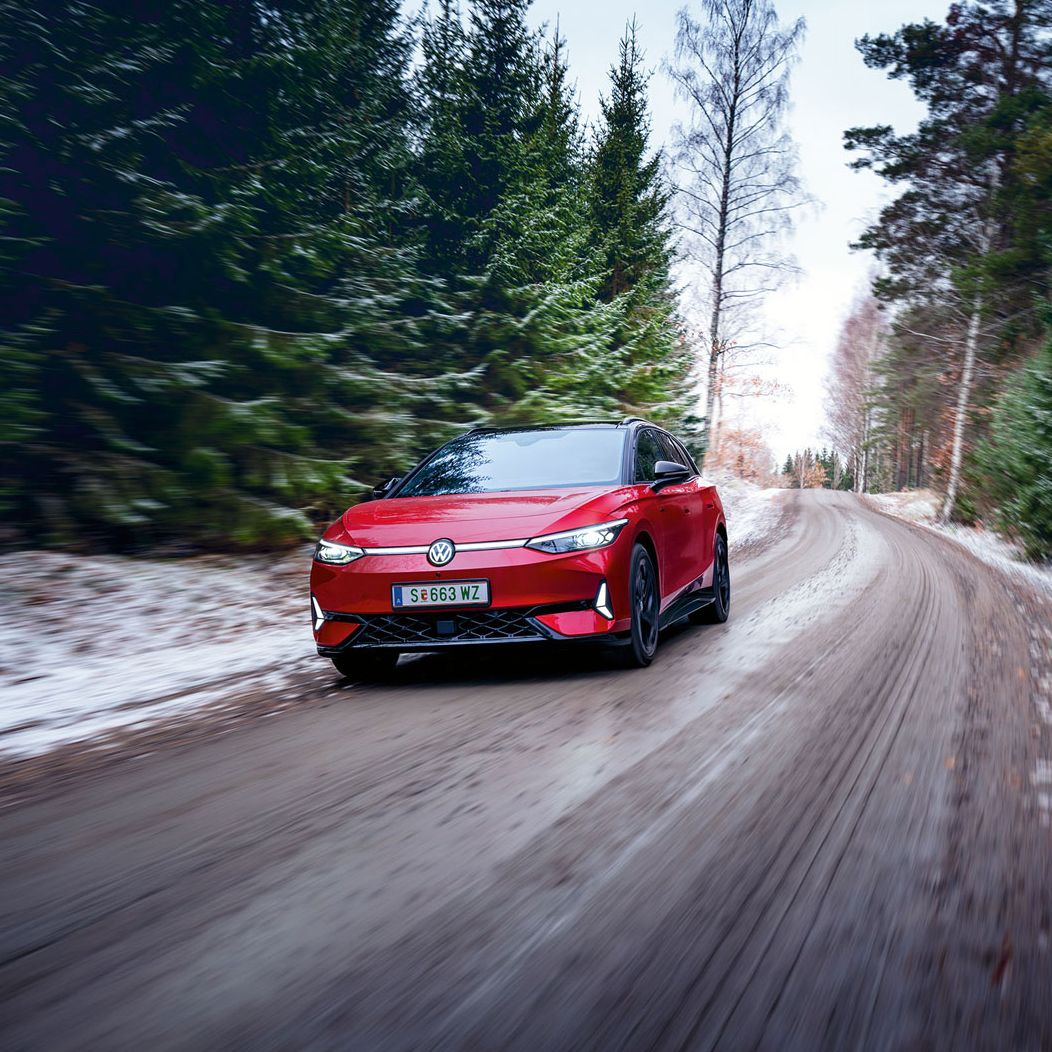 Ein roter VW ID.7 GTX fährt in Waldstraße im Winter