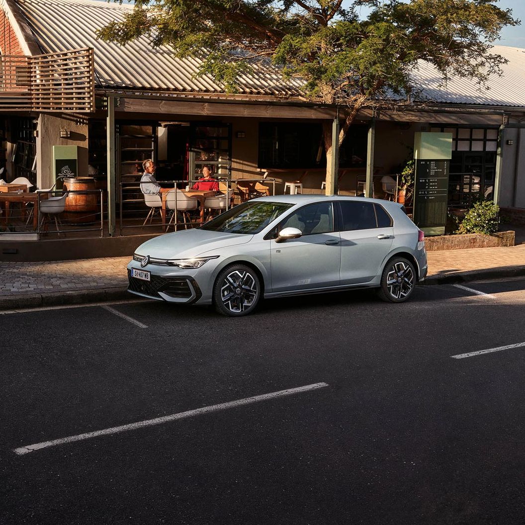 Der neue Golf GTE parkt an einem Straßenrand neben einem Café.