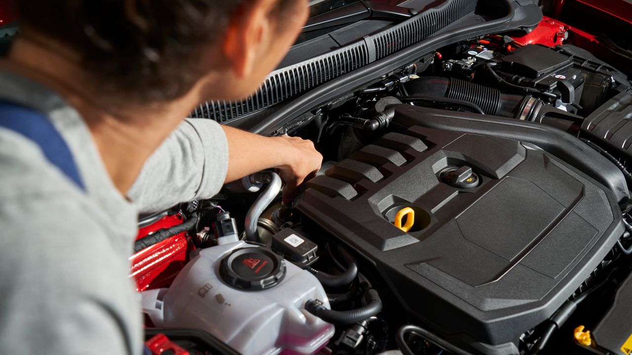 Ein VW Service Techniker wechselt die Glühkerzen bei einem Volkswagen