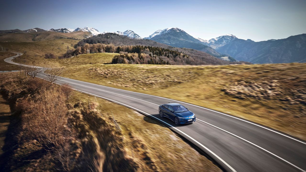 Ein blauer Volkswagen ID.7 in Fahrt auf einer Bergstraße.