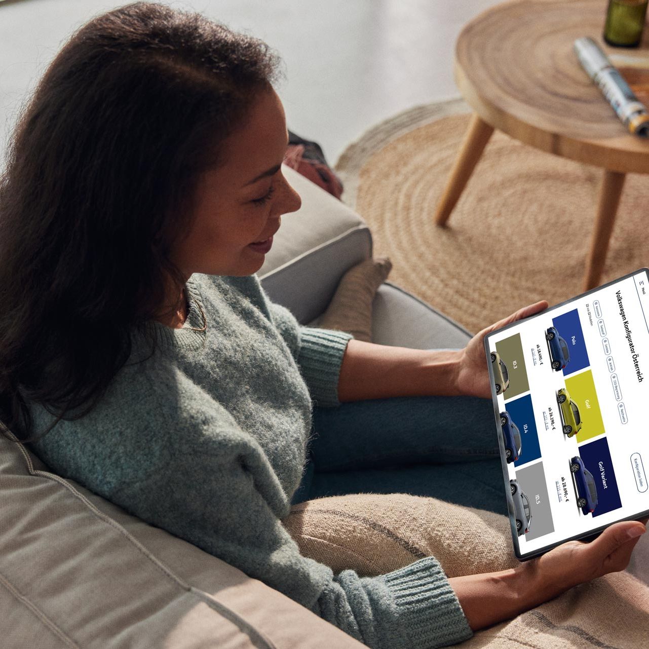 Eine Volkswagen Kundin blickt auf ein Tablet