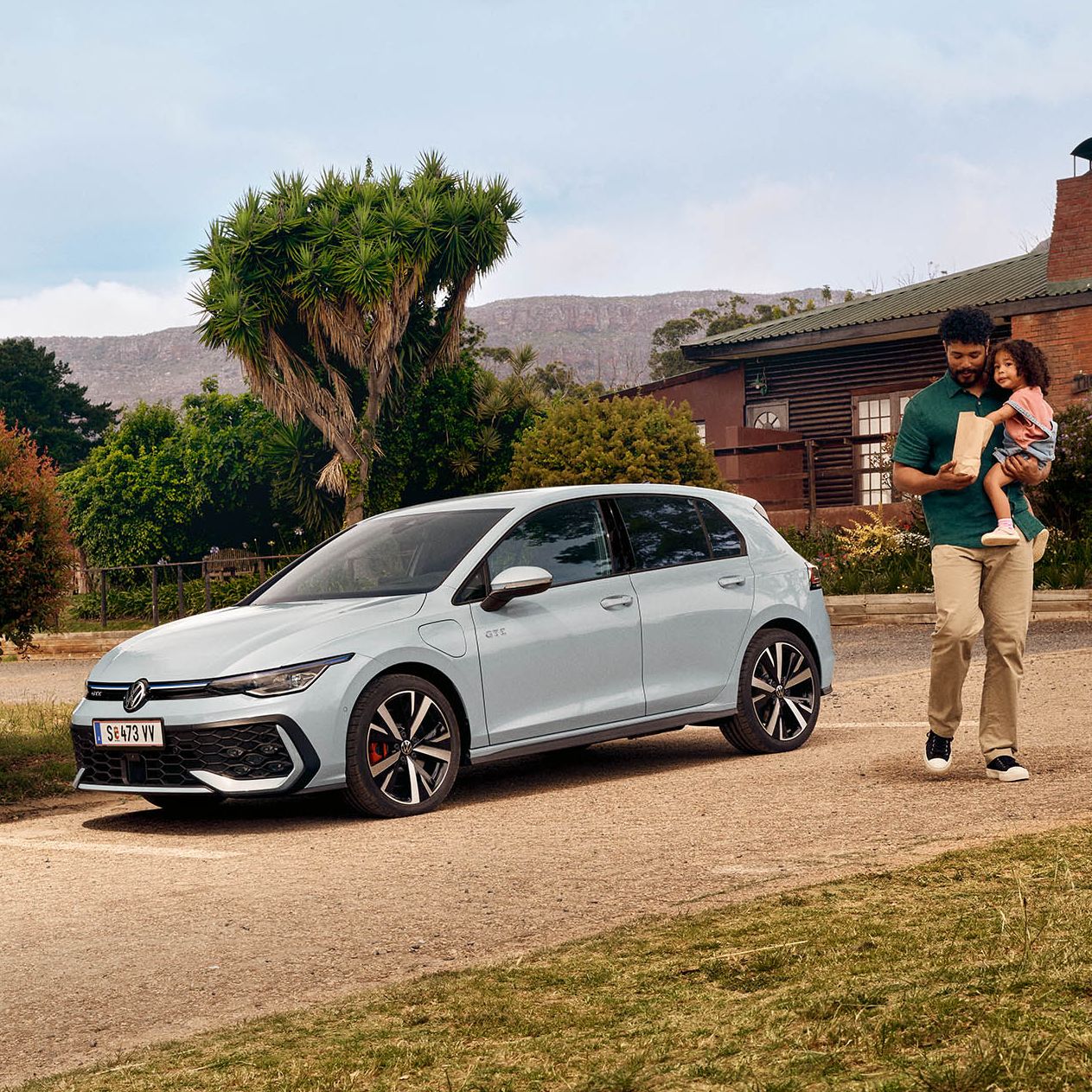 Der neue VW Golf GTE steht auf einem Parkplatz vor einem Haus.