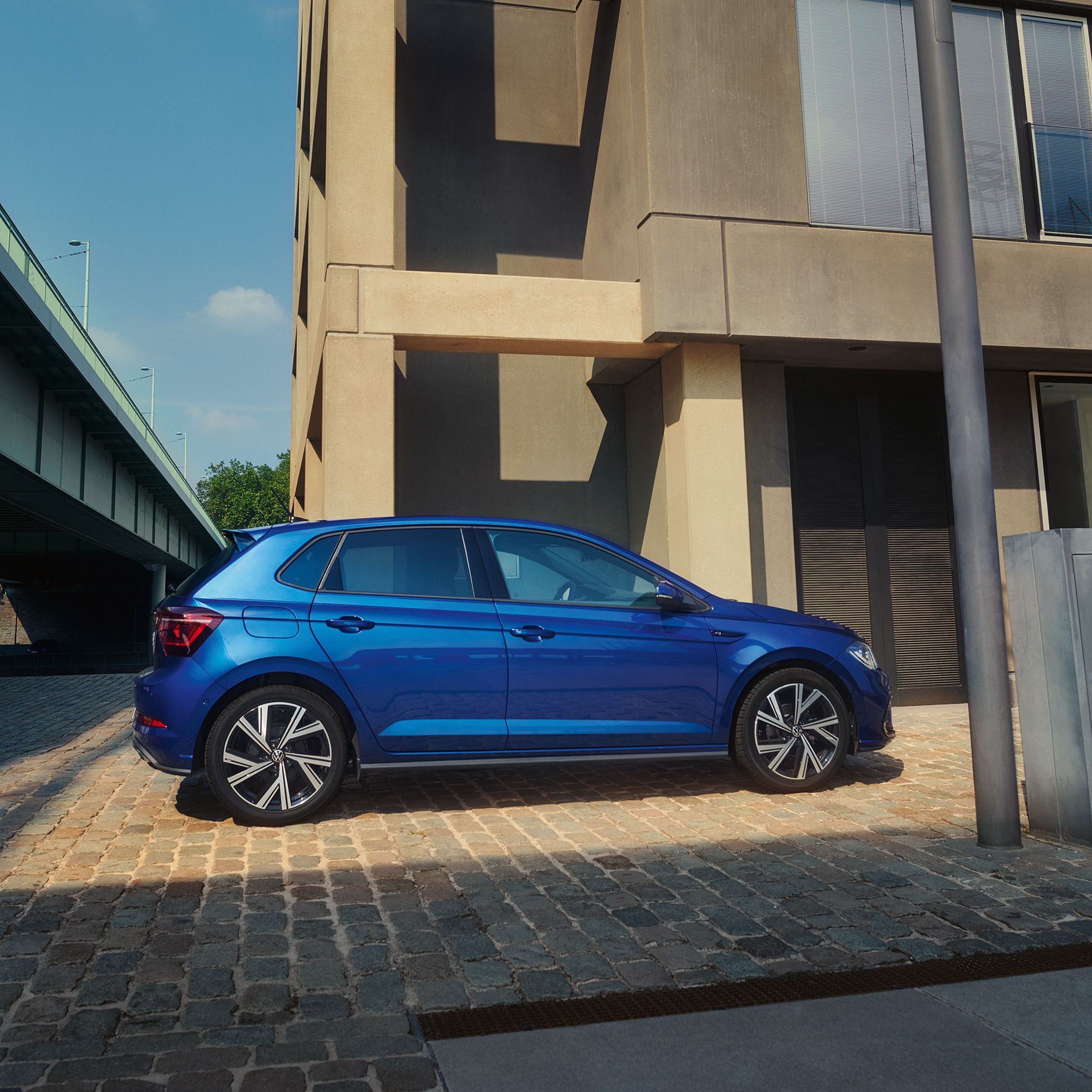 Seitenansicht eines blauen VW Polo R-Line in einer Stadt