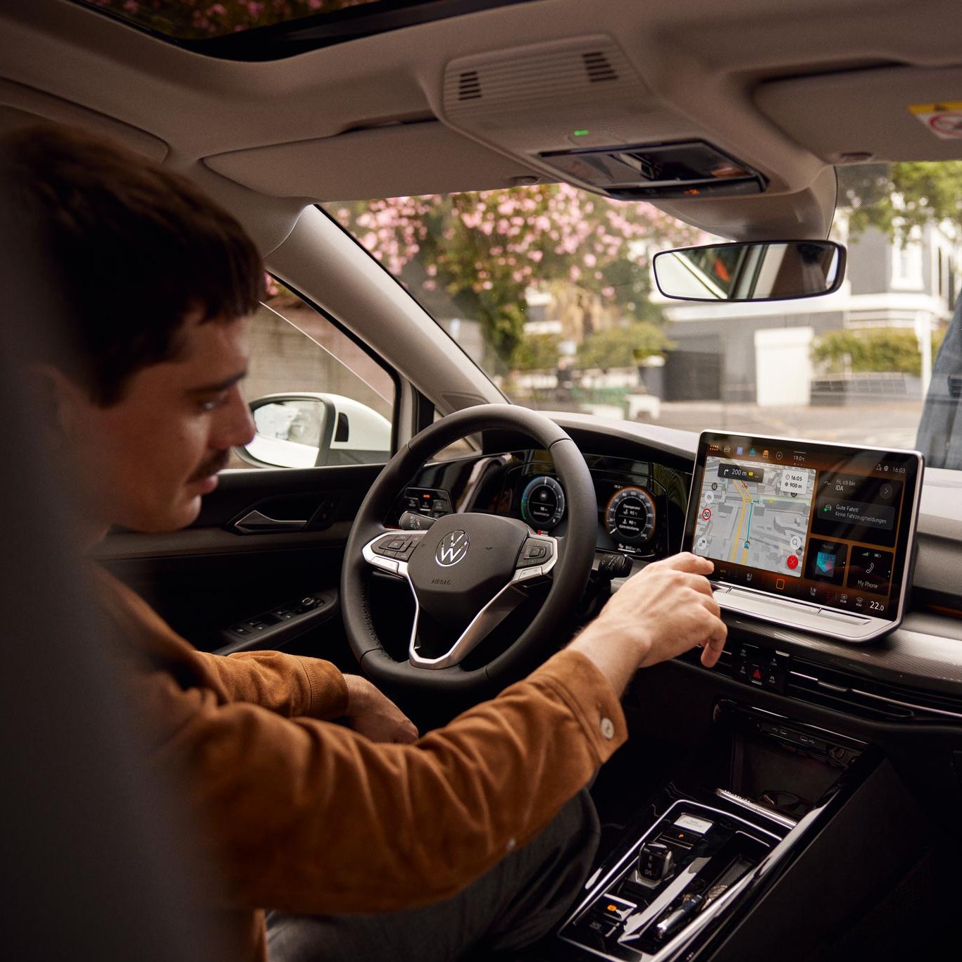 Man bedient Touchscreen des Infotainmentsystems im VW Golf