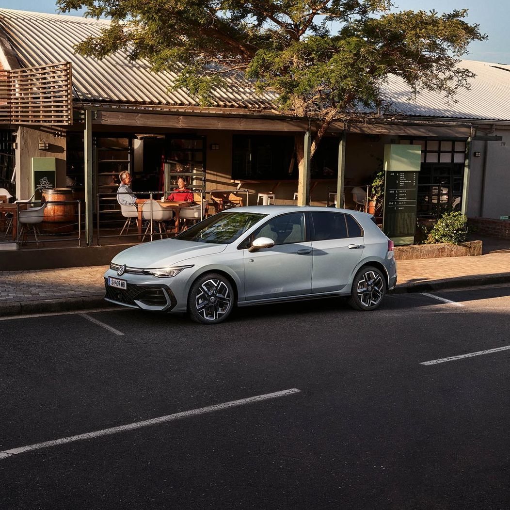 Der neue Golf GTE parkt an einem Straßenrand neben einem Café.