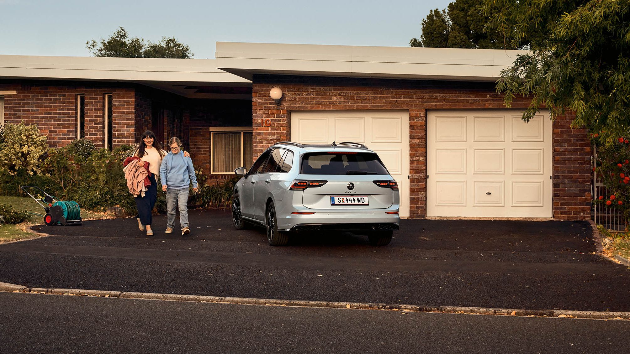 Heckansicht eines VW Golf Variant in der Farbe Ice Blue Metallic geparkt vor Einfamilienhaus