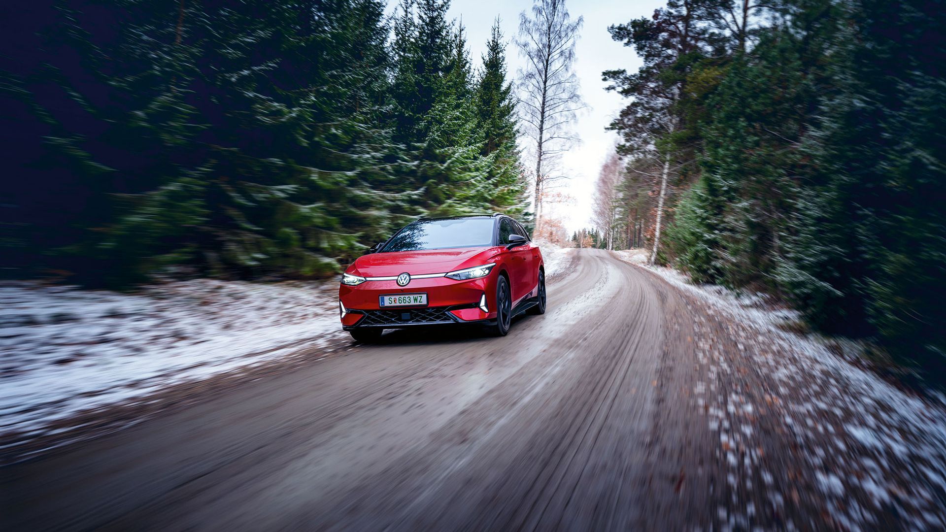 Ein roter VW ID.7 GTX fährt in Waldstraße im Winter