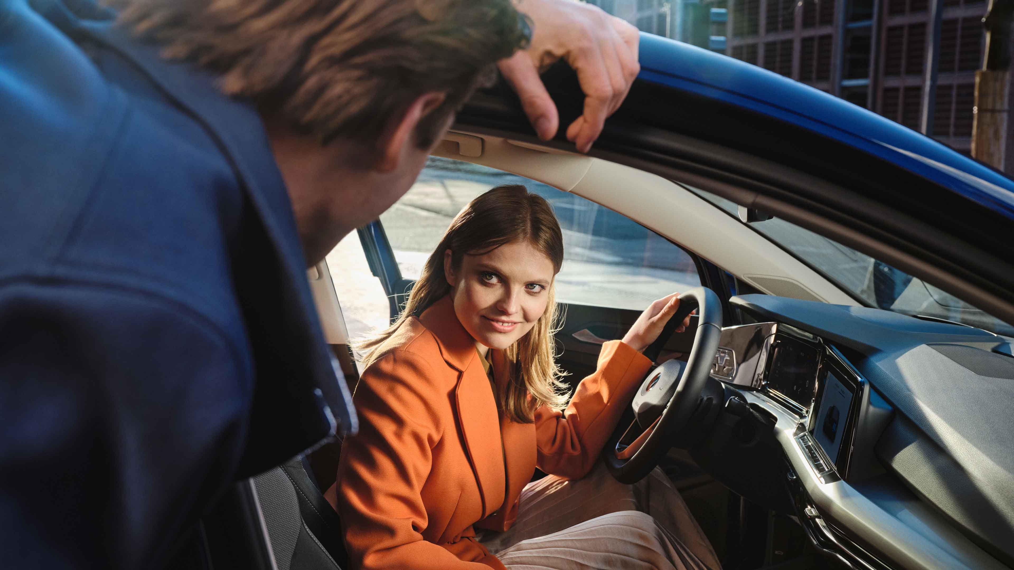 Frau sitzt in VW Golf eHybrid