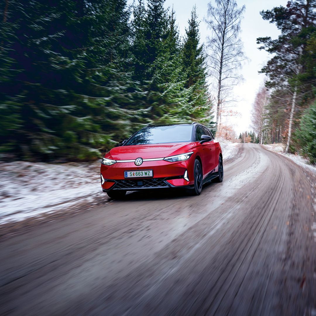 Ein roter VW ID.7 GTX fährt in Waldstraße im Winter