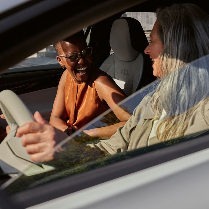 Blick in den VW ID.7 in dem zwei Frauen sitzen und lachen