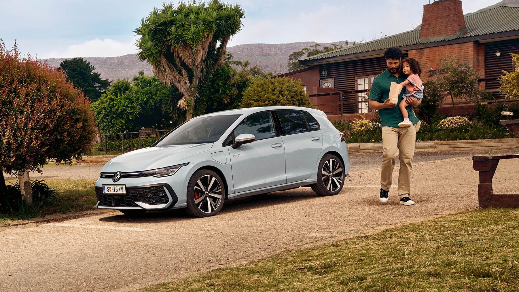 Der neue VW Golf GTE steht auf einem Parkplatz vor einem Haus.