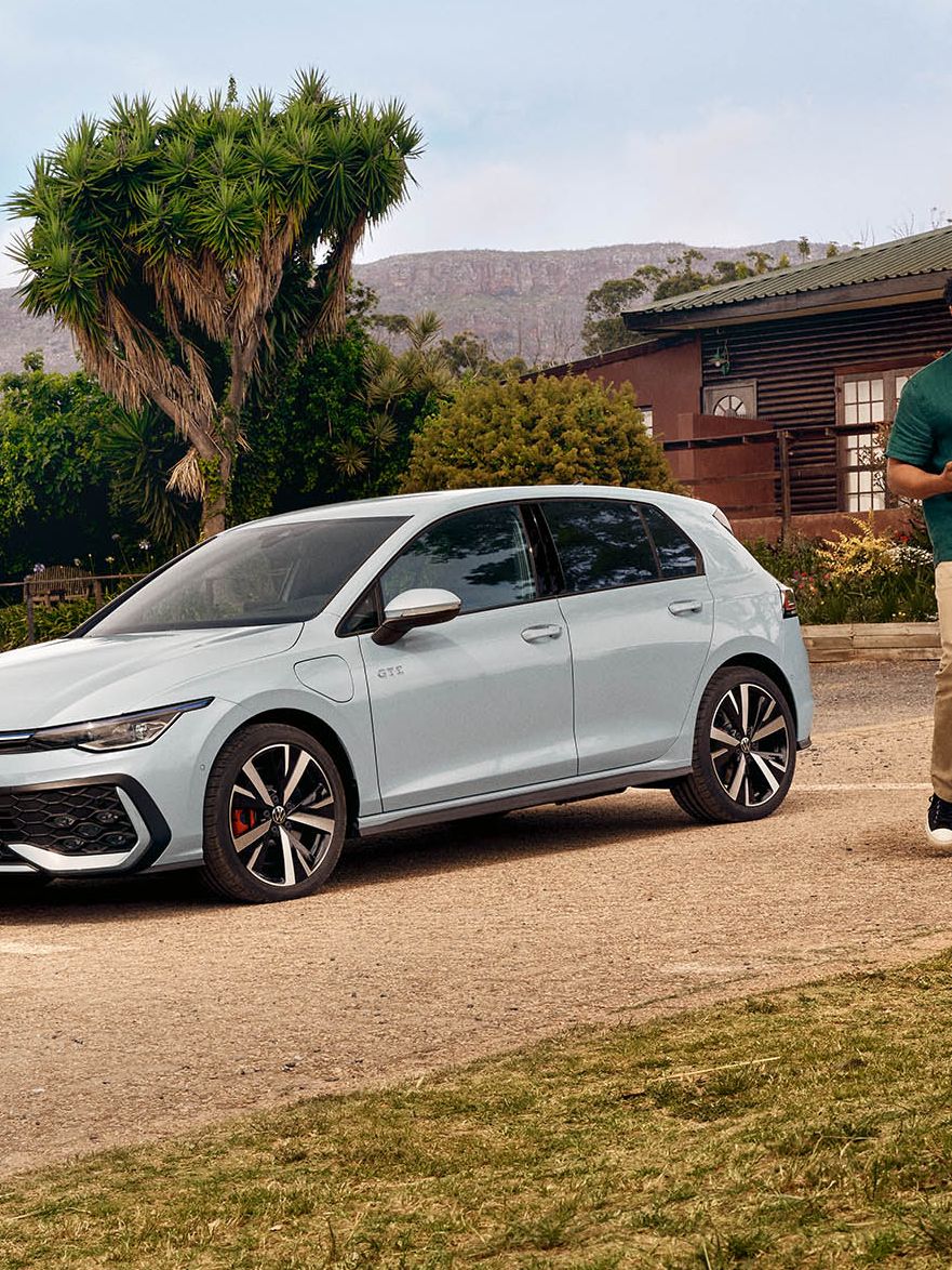 Der neue VW Golf GTE steht auf einem Parkplatz vor einem Haus.