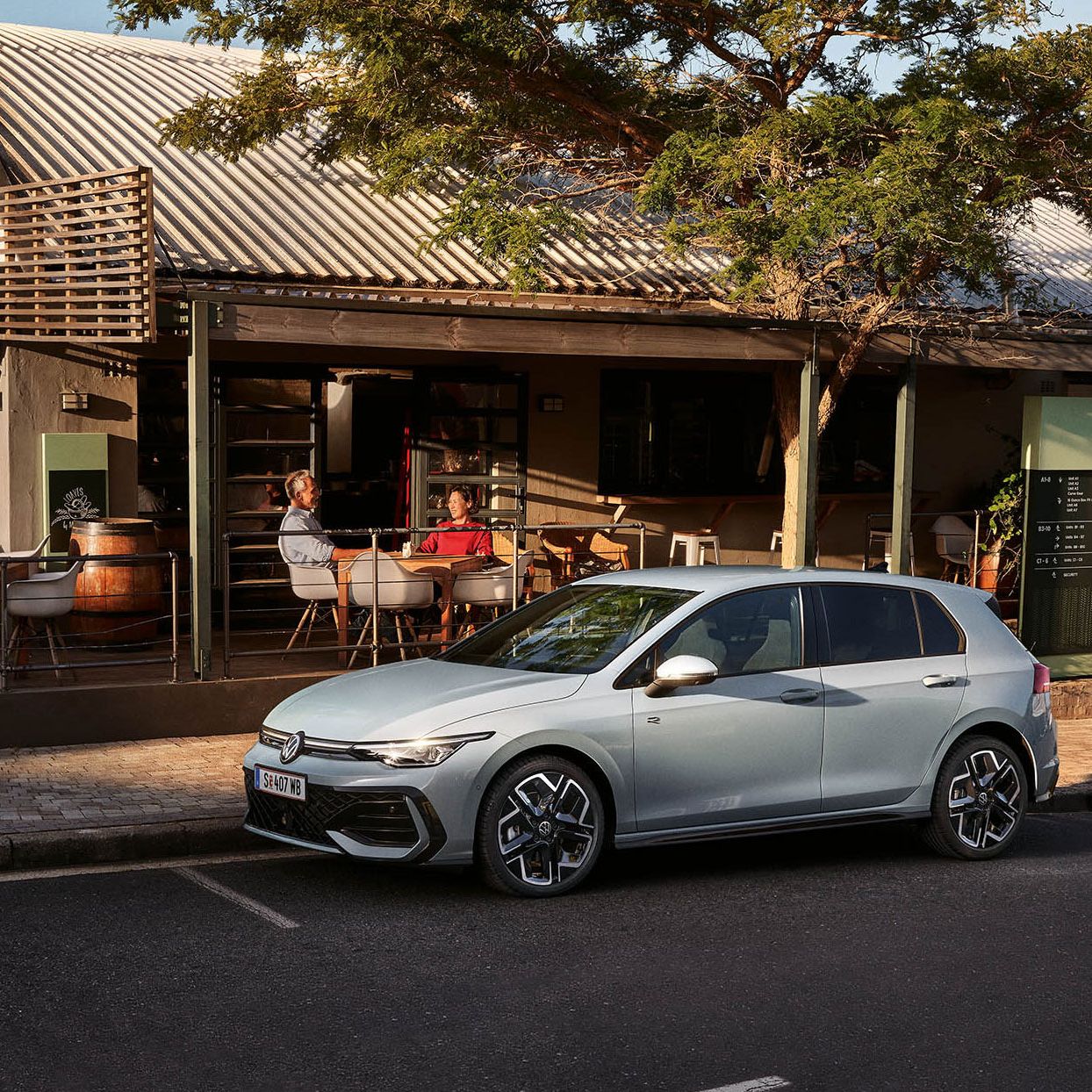 Der neue Golf GTE parkt an einem Straßenrand neben einem Café.