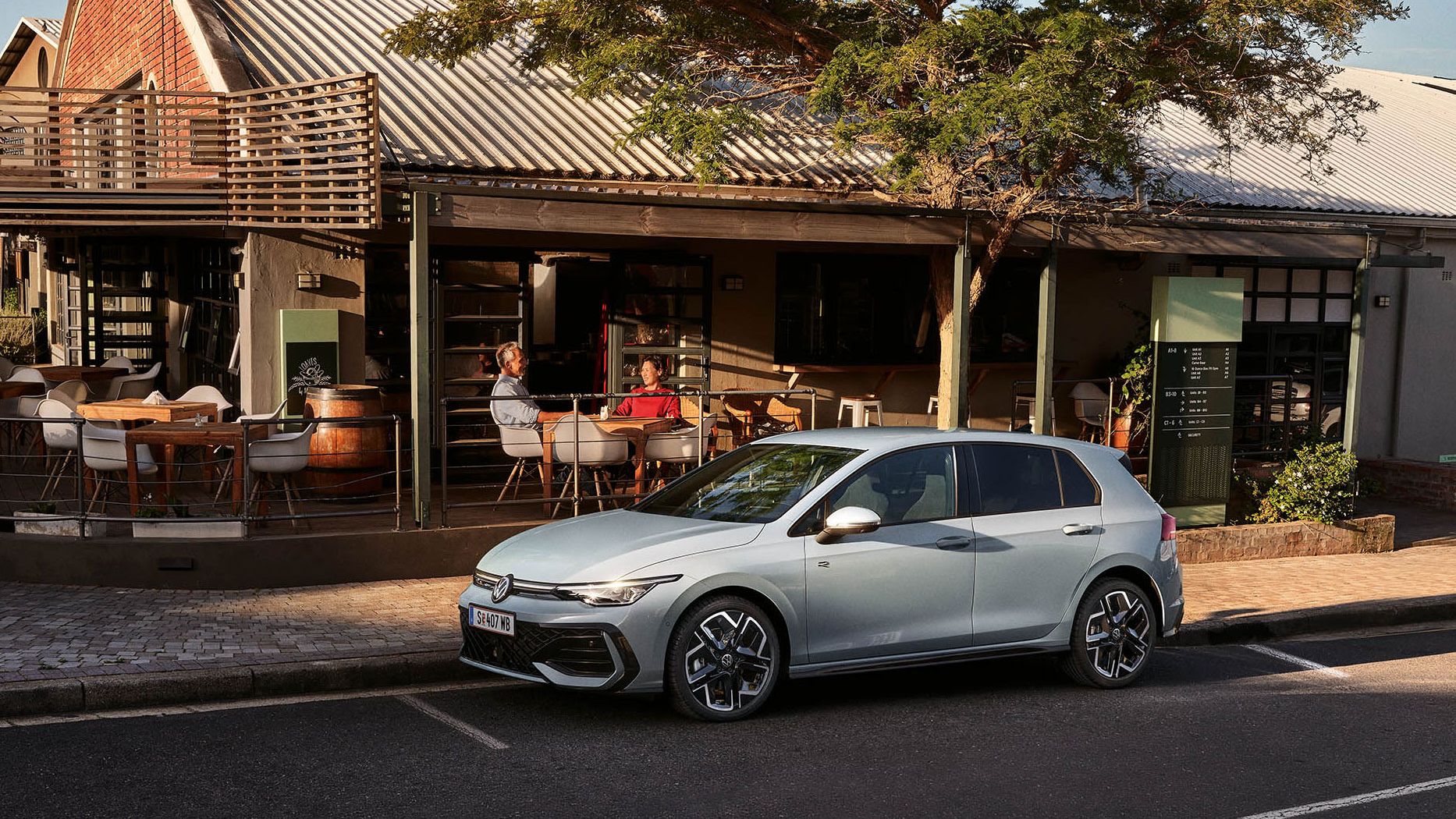 Der neue Golf GTE parkt an einem Straßenrand neben einem Café.