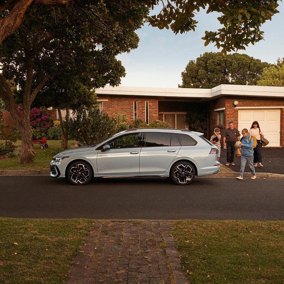 Seitenansicht eines VW Golf Variant in der Farbe Ice Blue Metallic geparkt vor Einfamilienhaus