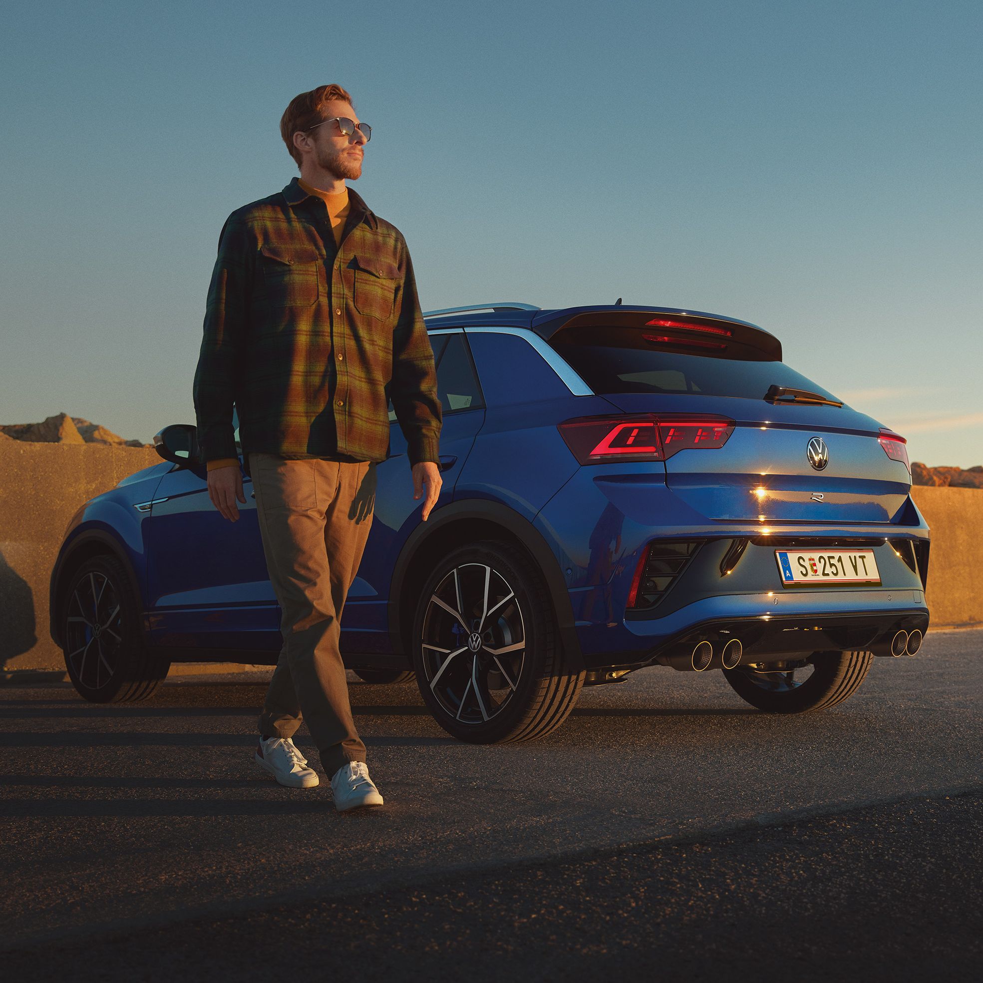 Mann geht an einem blauen VW T-Roc R vorbei