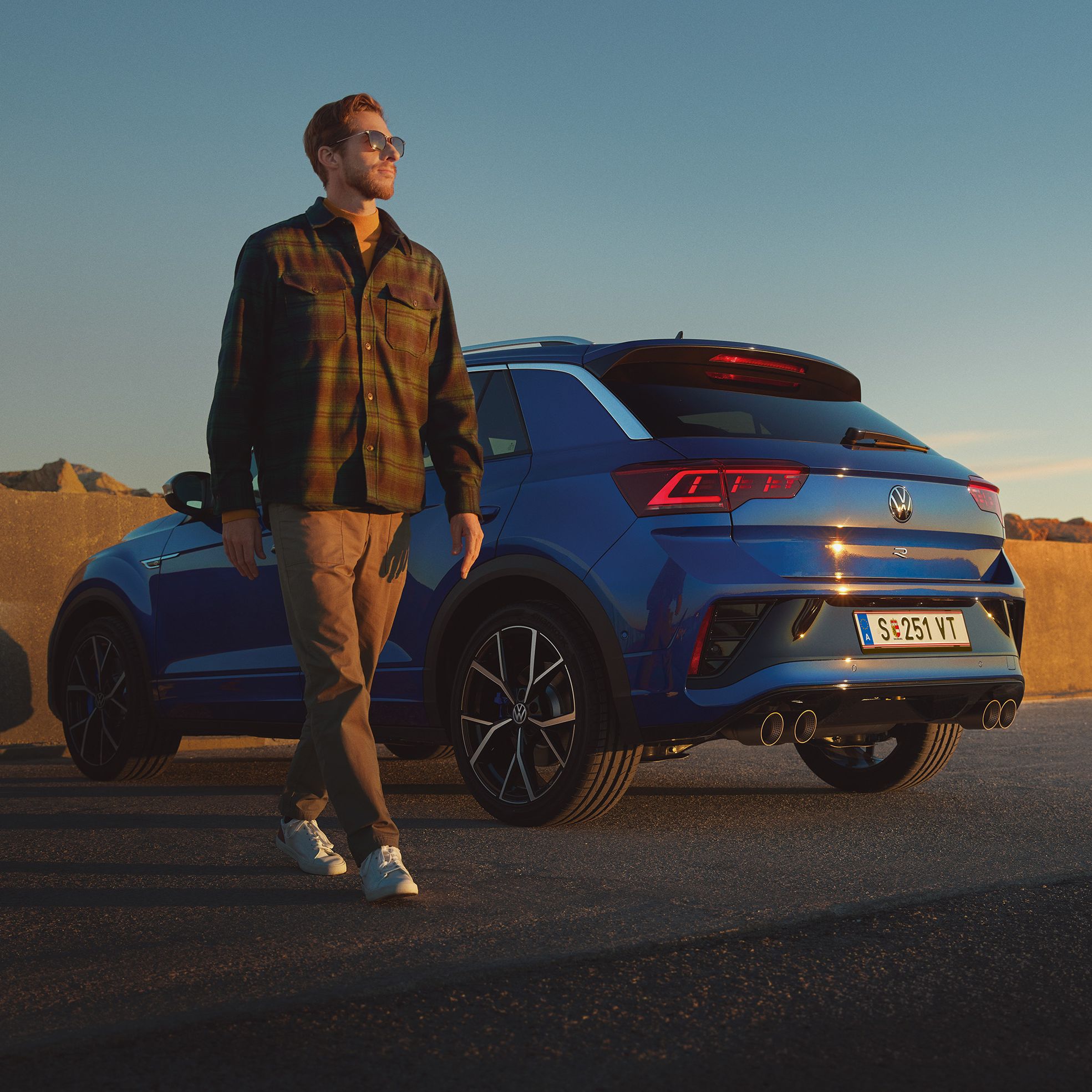 Mann geht an einem blauen VW T-Roc R vorbei