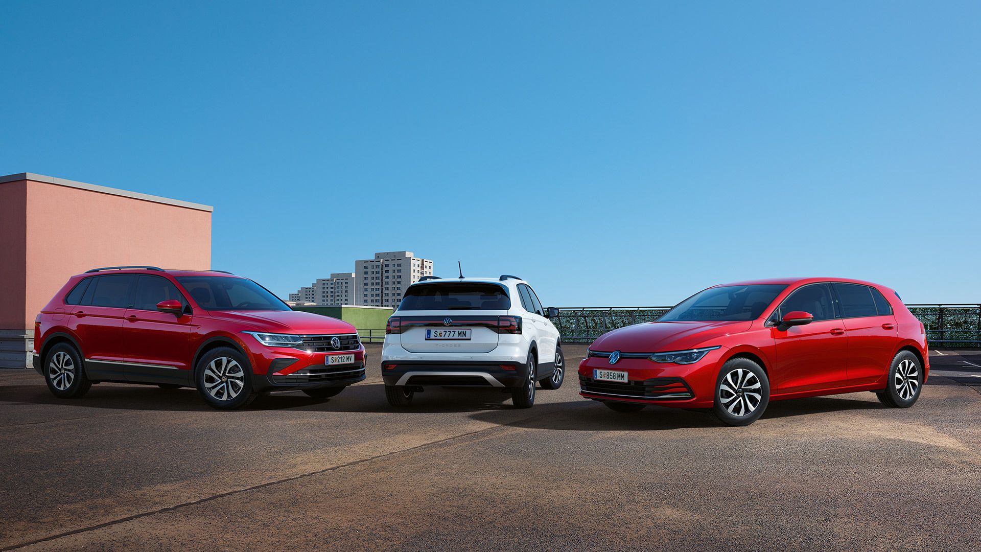 Ein VW T-Cross, VW Golf und VW Tiguan stehen nebeneinander vor einem blauen Himmel