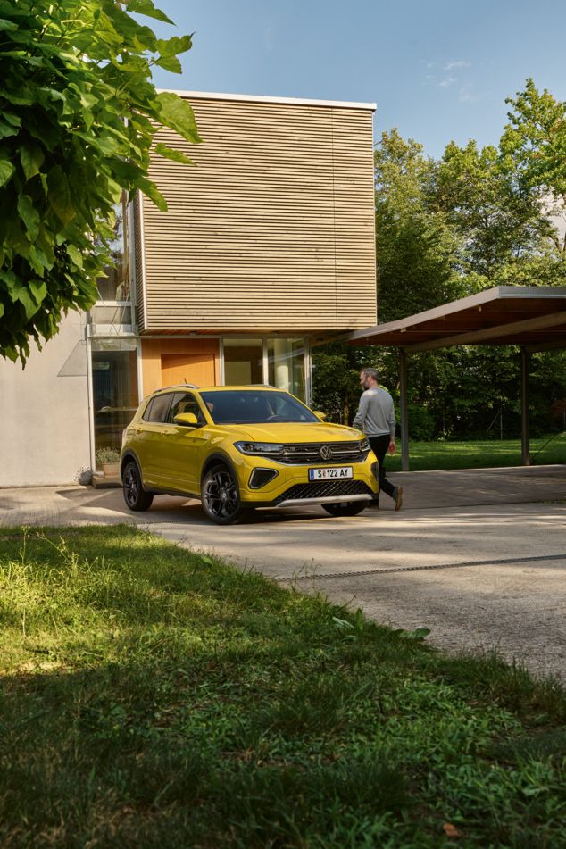 Ein VW T-Cross in gelb vor einem Einfamilienhaus