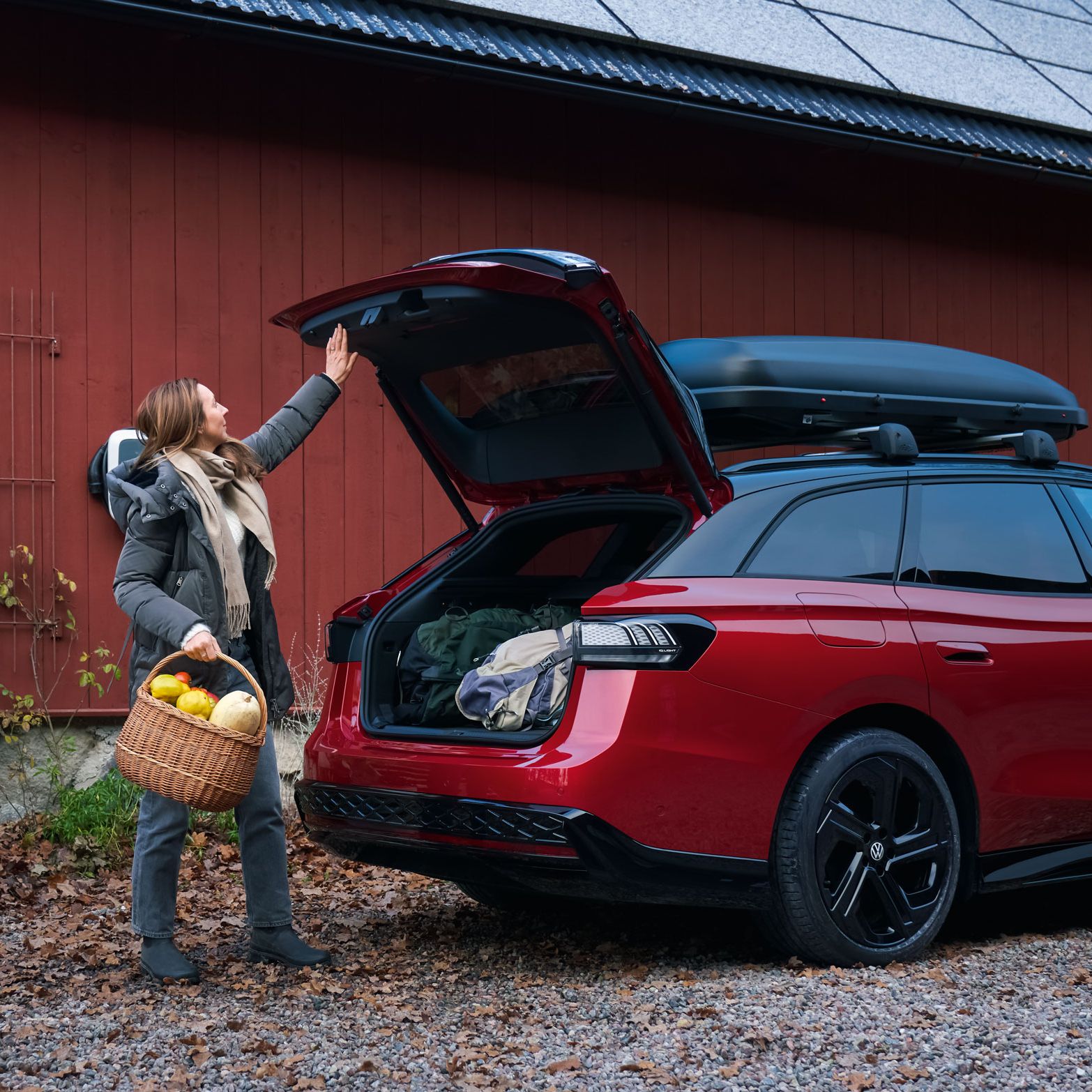 Eine Frau schließt die Heckklappe des VW ID.7 Tourer GTX per Knopfdruck