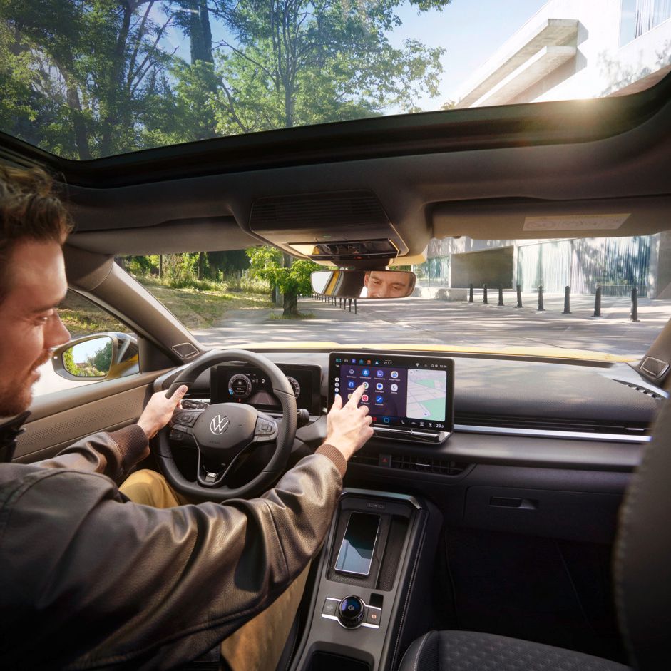 VW T-Roc Ein Mann bedient auf dem Infotainment-Display in seinem Volkswagen T-Roc Android Auto über die App-Connect Schnittstelle.