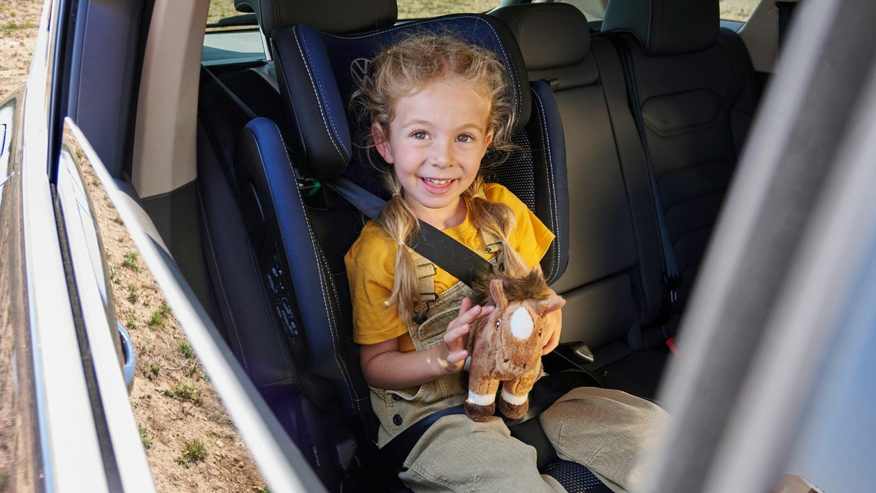 Ein Mädchen sitzt in einem Volkswagen Kindersitz