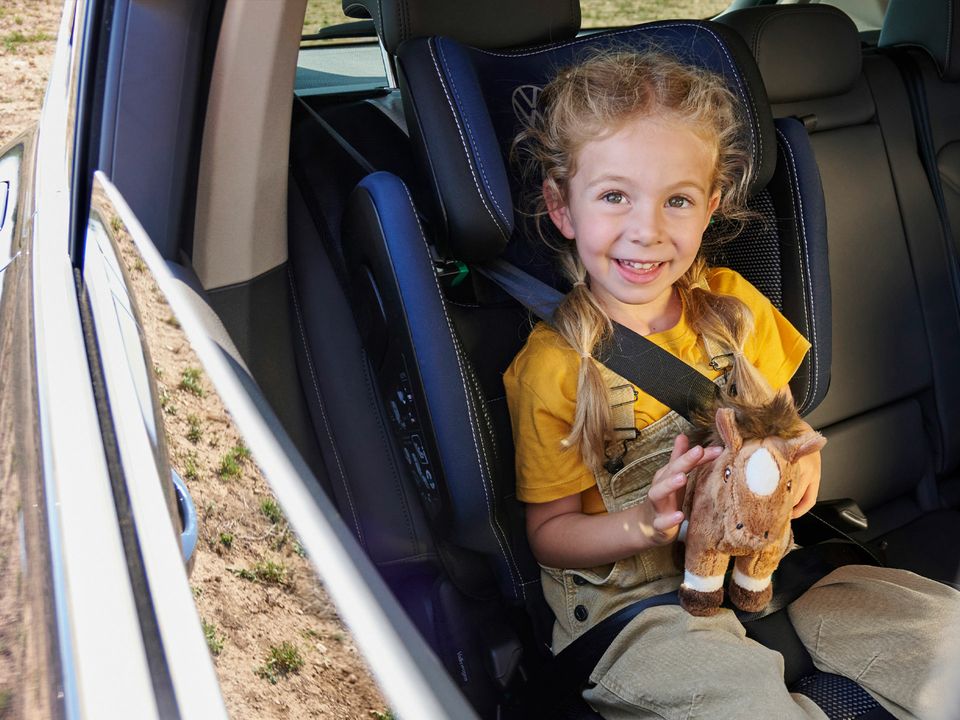 Ein Mädchen sitzt in einem Volkswagen Kindersitz