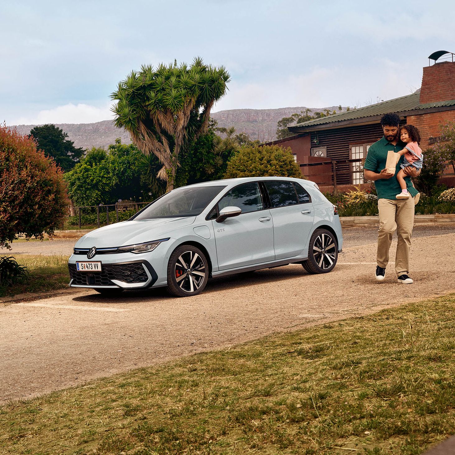 Der neue VW Golf GTE steht auf einem Parkplatz vor einem Haus.